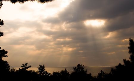 Sunlight breaking through clouds in the seaの写真素材