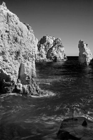 A small boat wharf beside rocks. black & white versionの写真素材