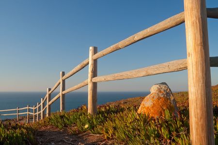 Wooden fence near the ocean before sunsetの写真素材