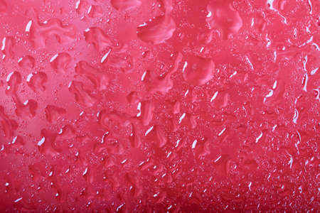Water drops on glass. Red backgroundの写真素材