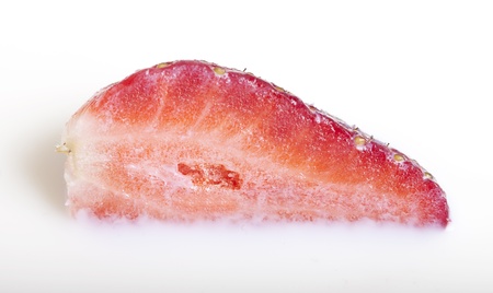 Half of strawberry in milk.の写真素材