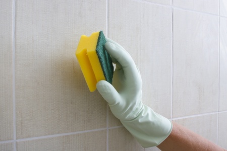 Hand cleaning tiled wall の写真素材