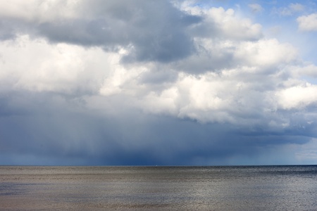 Clouds over dark and blue sea の写真素材