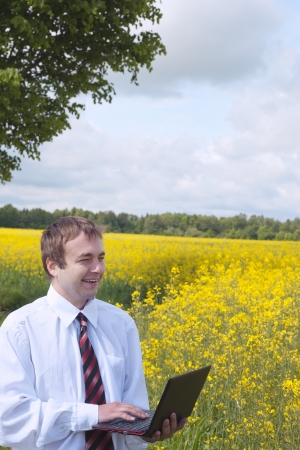 Farmer calculating earnings in canola field の写真素材