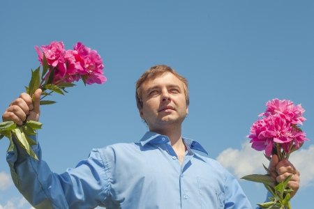 Man and flowers against blue sky の写真素材