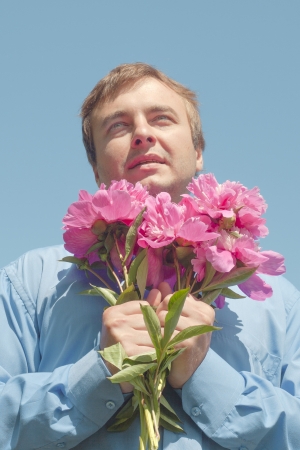 Man and flowers against blue sky の写真素材