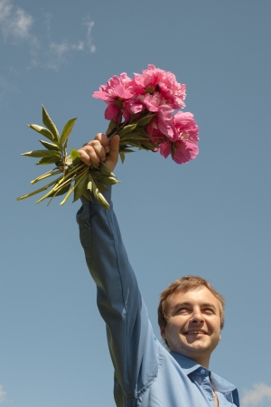 Man and flowers against blue sky の写真素材