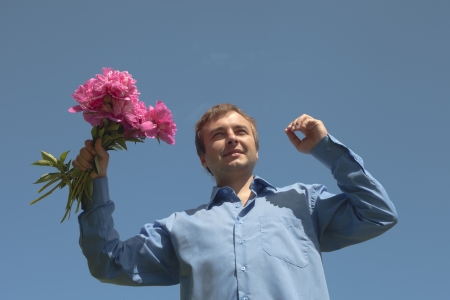 Man and flowers against blue sky の写真素材