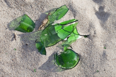 Broken glass in beach sand の写真素材