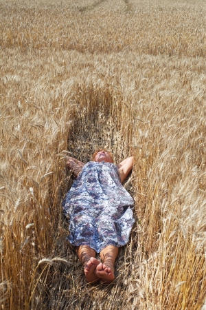 Woman relaxing in grain field の写真素材