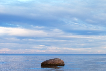 Lonely stone in blue Baltic sea の写真素材