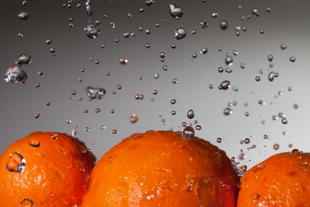 Water drops over ripe oranges の写真素材