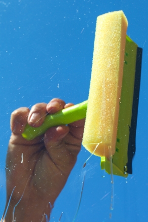Human hand washing window in nice summer day の写真素材