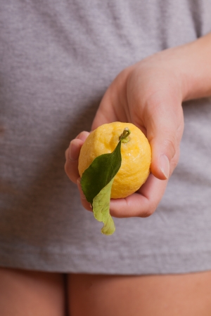 Hand holding fresh lemon の写真素材