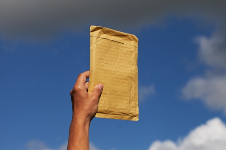 Yellow envelope against blue sky の写真素材