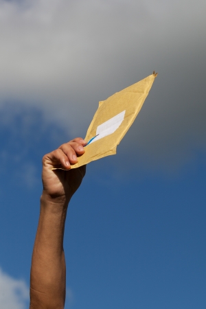 Yellow envelope against blue sky の写真素材