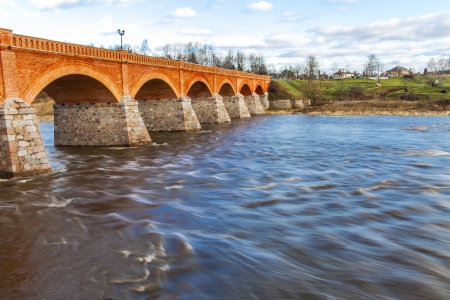 Old historical bridge over Venta river in Kuldiga, Latvia.の写真素材
