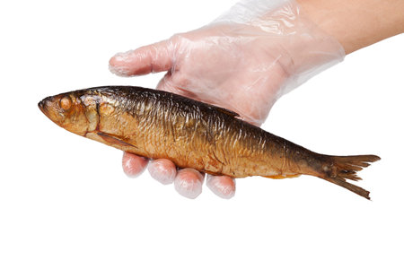 Smoked herring in hand isolated on white.