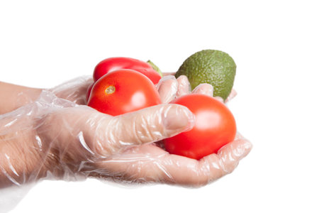 Ripe vegetables in gloved hand isolated on white.の写真素材