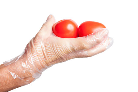 Ripe vegetables in gloved hand isolated on white.の写真素材