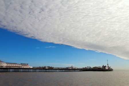 BRIGHTON - MARCH 5. Brighton pier under big cloud March 5, 2014 in East Sussex, England, United kingdom.のeditorial素材