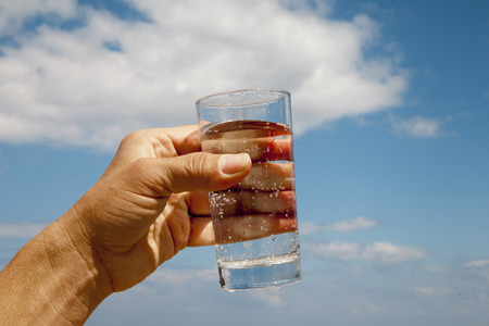 Glass of water in human hand.の写真素材