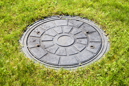 Drain cover in green grass.の写真素材
