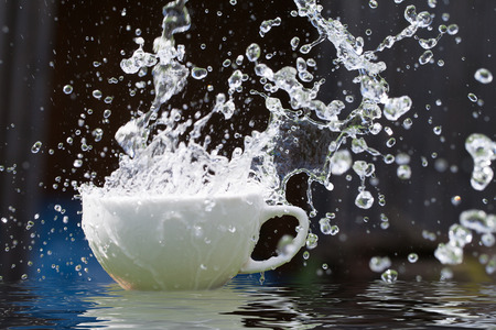 White cup and pouring water.の写真素材