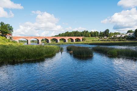 Old brick bridge across Venta river in Kuldiga, Latvia.の写真素材