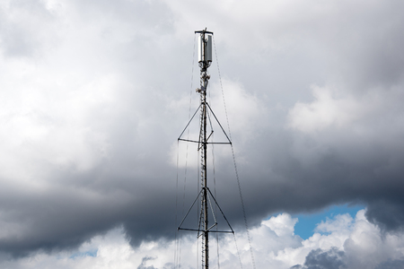 Antenna against white clouds.の写真素材