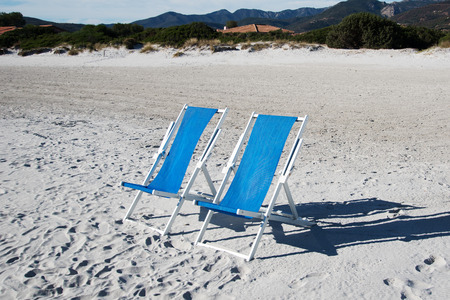 Blue chairs on beach sand.の写真素材