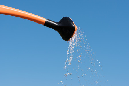 Watering can against blue sky.の写真素材