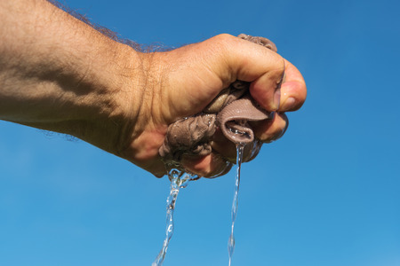 Mans hand  squeeze out wet fabric.の写真素材
