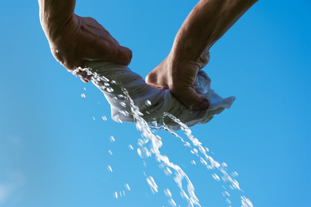 Hands squeeze wet cloth.の写真素材