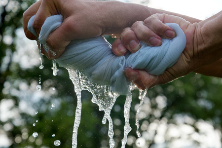 Hands squeeze wet cloth.の写真素材