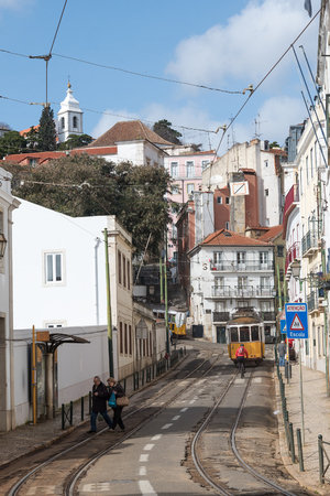 Lisbon, Portugal - FEBRUARY 7 , 2016 : typical old style tram passing narrow city street in Lisbon , Portugal.のeditorial素材
