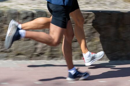 Running legs on sunny pavement.の写真素材