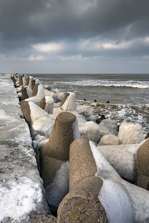 Icy breakwater in winter time.の写真素材