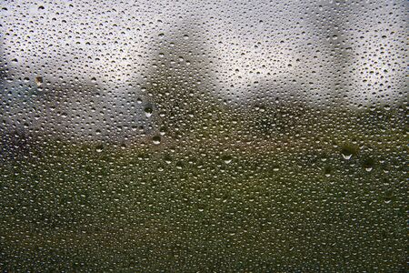 Water drops on window and rural landscape.の写真素材
