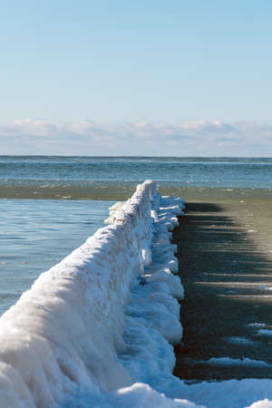 Icy fishing boat pier at Baltic sea coast.の写真素材