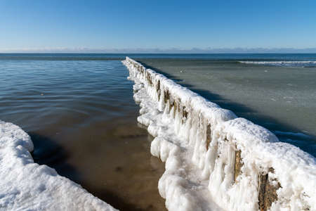 Icy fishing boat pier at Baltic sea coast.の写真素材