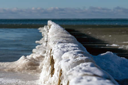 Icy fishing boat pier at Baltic sea coast.の写真素材