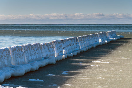 Icy fishing boat pier at Baltic sea coast.の写真素材