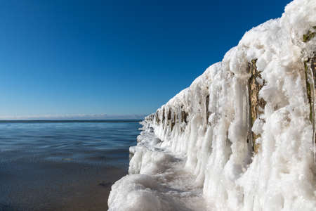 Icy fishing boat pier at Baltic sea coast.の写真素材