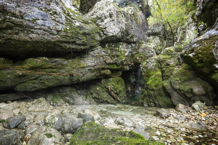 Small creek making tiny waterfalls dripping from rocksの写真素材