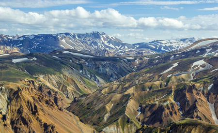 High colorful mountain ridge with mountain peaks covered by snow from summit of Blahnakur mountain, Landmannalaugar, Icelandの写真素材