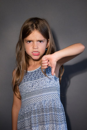 little girl showing thumb downの写真素材