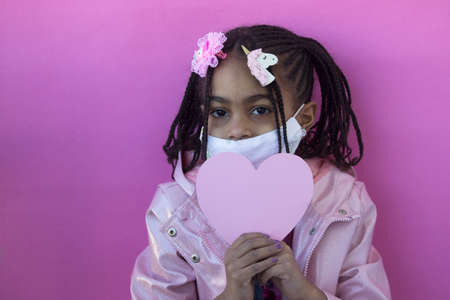 Portrait of little multiracial girl wearing medical maskの写真素材