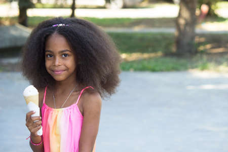 cute mixed girl eating an ice creamの写真素材