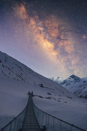 Bridge to the sky. Milky way under the snowy mountains in the night. Gangapurna 7455 m and Annapurna III 7555 m on the background.の写真素材